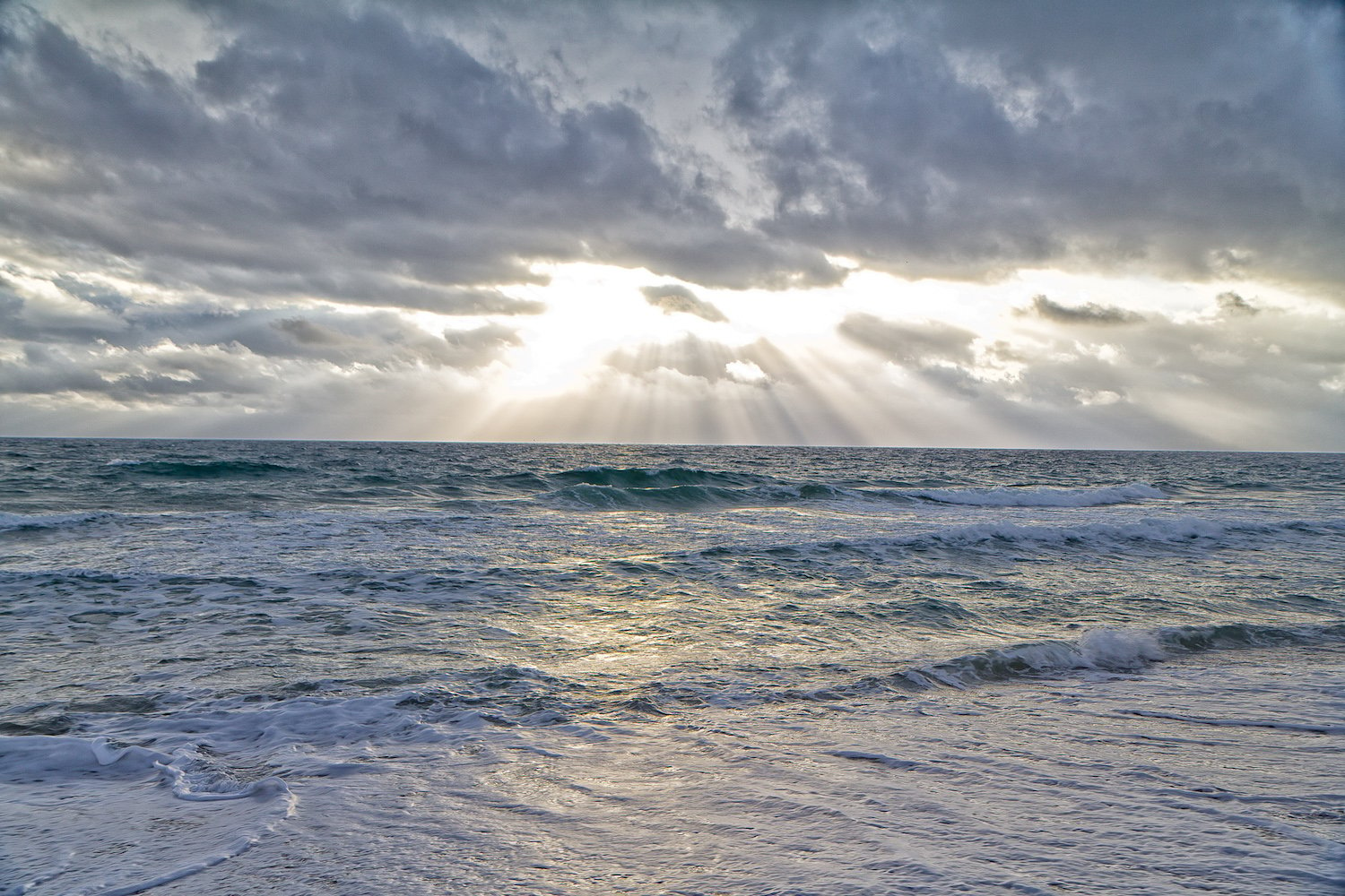 Picture of sun coming through clouds above Atlantic Ocean